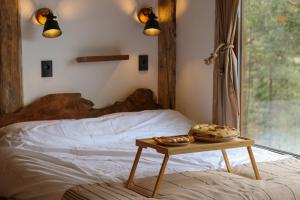 a bed with a table with two cookies on it at Rustic Cabin Zlatibor in Ribnica