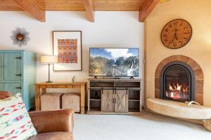 a living room with a fireplace and a tv at Riverside Condos D01 by AvantStay Condo Close To Downtown Town Park Ski Lift 8 in Telluride