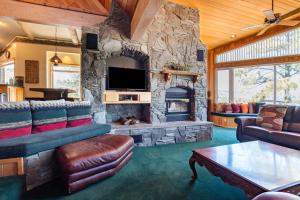 sala de estar con chimenea de piedra y sofá en Timberline Lodge by AvantStay Secluded Hill Top Home w Incredible Views, en Big Bear Lake