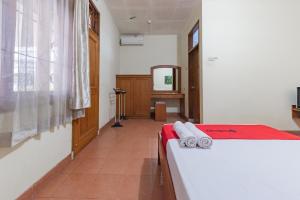 Postel nebo postele na pokoji v ubytování RedDoorz Plus at Wisma Kenanga Sukabumi