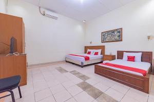 Postel nebo postele na pokoji v ubytování RedDoorz Plus at Wisma Kenanga Sukabumi