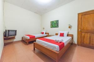 Postel nebo postele na pokoji v ubytování RedDoorz Plus at Wisma Kenanga Sukabumi