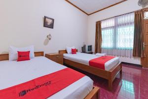 Postel nebo postele na pokoji v ubytování RedDoorz Plus at Wisma Kenanga Sukabumi
