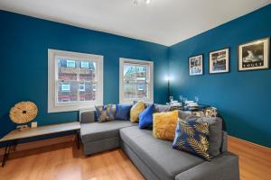a living room with blue walls and a couch at Chapel Manor Large 2 Bed Flat Zone 1 in London