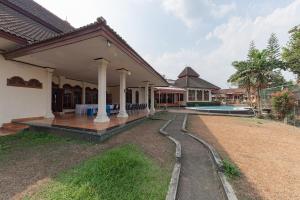 a house with a porch and a swimming pool at RedDoorz Plus near RSUD R. Syamsudin Bunut Sukabumi in Sukabumi