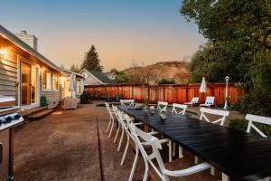 una larga mesa negra y sillas blancas en un patio en Cabernet By AvantStay Tranquil Sonoma Valley Oasis w Pool Fire Pit, en Santa Rosa