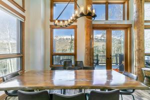 ein Esszimmer mit einem Tisch, Stühlen und Fenstern in der Unterkunft Adams Ranch Retreat by AvantStay Free Shuttle 2 Mountain Village Telluride Ski Resort in Telluride