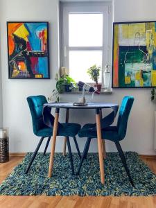 a dining room table with two blue chairs on a rug at Beautiful bright apartment with balcony/10’ Mitte in Berlin