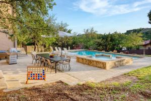 un patio con mesa y sillas junto a una piscina en Hudson by AvantStay Magnificent Home w Beautiful Views Multiple Living Areas Pool Games en Austin