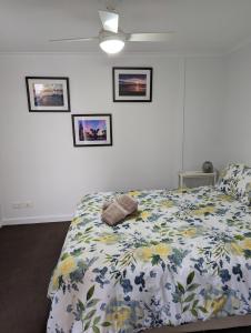 a bedroom with a bed with a floral comforter at The Heart of Glenelg in Glenelg