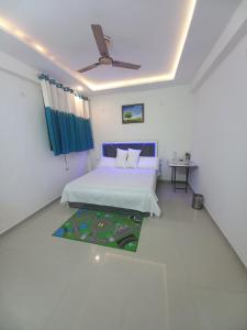 a bedroom with a bed and a ceiling fan at Paradise Homes in Agra