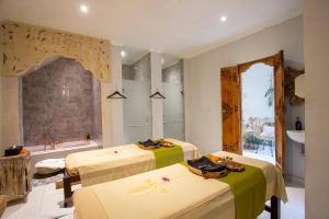 a room with two beds and a bath tub at Awatara Boutique Resort Ubud in Ubud