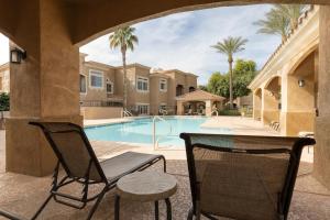 a patio with two chairs and a swimming pool at Eucalyptus by AvantStay Stunning Scottsdale Home w Communal Pool Hot Tub in Scottsdale