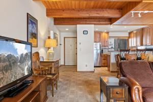 een woonkamer met een tv en een keuken bij Riverside Condos A103 by AvantStay Condo Close To Downtown Town Park Ski Lift 8 in Telluride