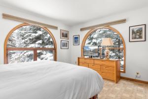 een slaapkamer met een bed en 2 grote ramen bij Riverside Condos A103 by AvantStay Condo Close To Downtown Town Park Ski Lift 8 in Telluride