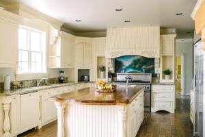 a kitchen with white cabinets and a kitchen island at Warhol by AvantStay Expansive Estate Stunning Wine Cty Views in Sage