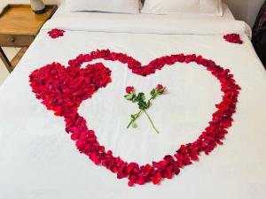 a heart made out of red flowers on a bed at Heart of Africa Lodge in Arusha