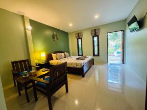 a bedroom with a bed and a table and chairs at AJ Paradise Resort Aonang Krabi in Ao Nang Beach