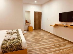 a bedroom with a bed and a flat screen tv at Hotel Park Airport Zone Hyderabad in Shamshabad
