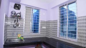 eine Küche mit einem Waschbecken und einem Fenster in der Unterkunft The Royals Home Stay in Deoghar