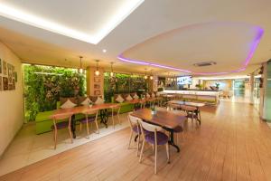 ein Restaurant mit Tischen, Stühlen und Pflanzen in der Unterkunft Heef Hotel in Jakarta