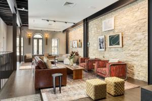 a lobby with couches and chairs and a brick wall at Paramount Place by AvantStay 4 Story Apartment in Heart of Austin w Movie Theatre in Austin