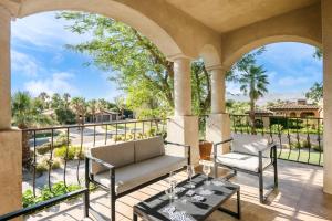a patio with a couch and chairs on a balcony at Villa Verbena by AvantStay Expansive Estate w B-ball Court PoolSpa Entertainers Yard in Bermuda Dunes