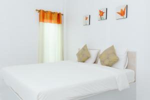 2 Betten in einem weißen Zimmer mit Fenster in der Unterkunft เพลินพฤกษารีสอร์ท in Ban Bang Rin (1)