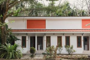 ein weißes Haus mit rotem Dach in der Unterkunft เพลินพฤกษารีสอร์ท in Ban Bang Rin (1)