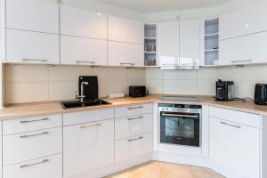 a white kitchen with white cabinets and appliances at Am Seedeich 14, AS7 in Cuxhaven