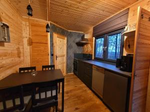 a kitchen with a table and a dining room at NEU Luxuriöses Tinyhaus Ferienhaus FREYR einmalig in Lübbenau in Klein Klessow