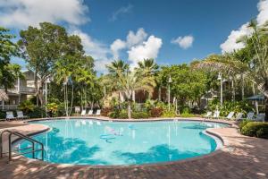 a swimming pool at a resort with palm trees at Coral Villa by AvantStay Close 2 DT Key West Shared Pool Month Long Stays Only in Stock Island