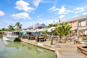 a dock with a restaurant and a boat on the water at Coral Villa by AvantStay Close 2 DT Key West Shared Pool Month Long Stays Only in Stock Island