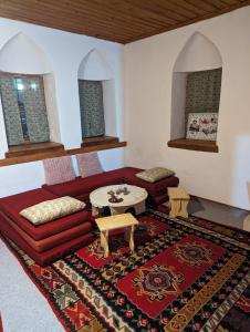 a living room with a red couch and a table at National Monument Konak in Stolac +30 photos