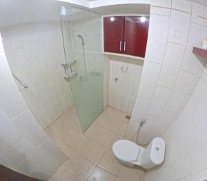 a bathroom with a toilet and a glass shower at Mataram City 1816 by We Stay in Kejayan +6 photos