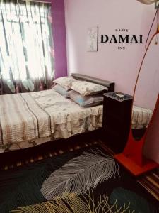 居鑾的住宿－NANIE DAMAI INN，卧室配有一张挂有墙上标志的床