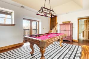 a pool table in a living room with a pink at Pine Needle by AvantStay Log Cabin w Gorgeous Views Hot Tub Patio Pool Table in Gatlinburg