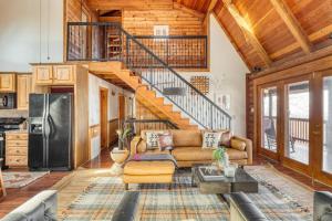 a living room with a couch and a staircase at Pine Needle by AvantStay Log Cabin w Gorgeous Views Hot Tub Patio Pool Table in Gatlinburg