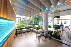 eine Terrasse mit Stühlen, einem Tisch und einem großen Aquarium in der Unterkunft Heef Hotel in Jakarta