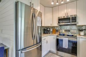 a kitchen with white cabinets and a stainless steel refrigerator at Flaglers Oasis by AvantStay Private Pool in Key West Month Long Stays Only in Key West