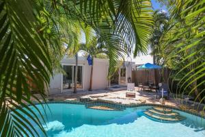 a pool with palm trees in front of a house at Flaglers Oasis by AvantStay Private Pool in Key West Month Long Stays Only in Key West