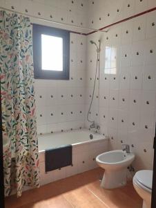 baño con bañera, aseo y ventana en Cortijo el Morisco., en Espera