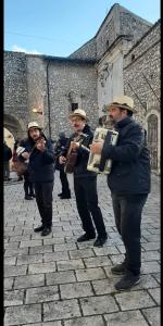 un gruppo di uomini che suonano strumenti davanti a un edificio di B&B Nonno Severino a Santo Stefano di Sessanio