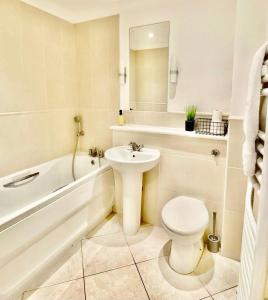 a white bathroom with a toilet and a sink at 4 Beds 2 Bath Close To Gen-hospital Free Parking in Southampton