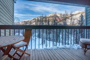 balcón con mesa, sillas y vistas a la montaña en Riverside Condos C202 by AvantStay Condo Close To Downtown Town Park Ski Lift 8, en Telluride