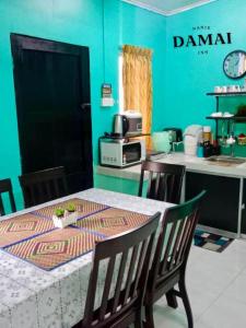 居鑾的住宿－NANIE DAMAI INN，一间带桌椅的用餐室和一间厨房