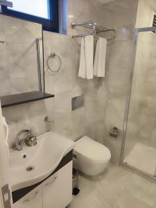 y baño con aseo, lavabo y ducha. en Hotel Esve Istanbul en Estambul