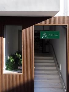 a building with a green exit sign and stairs at Athens Hills, Boutique Apartments in Athens