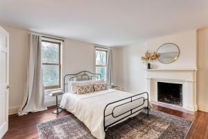 Dormitorio blanco con cama y chimenea en Hudson Estate Historic Upstate Home Private Apartment, en Saugerties