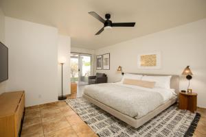a bedroom with a bed and a ceiling fan at 5mins to Coachella Grounds Petit Sahara by AvantStay in La Quinta